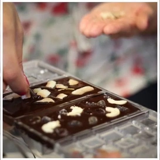 filling a chocolate mold during a chocolate making workshop